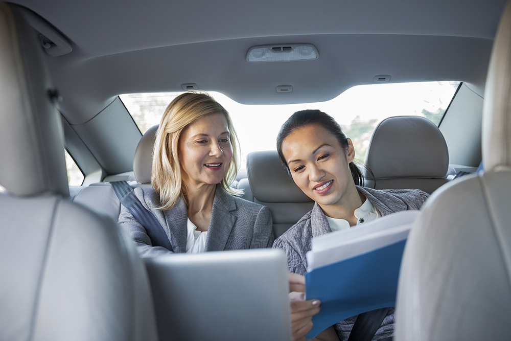 Business colleagues reviewing paperwork in car