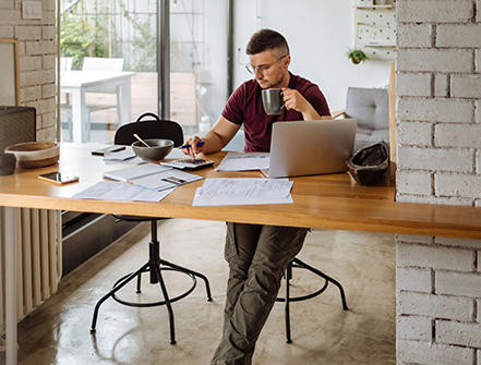 Young man at home, paying bills online