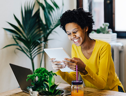 Young woman sitting at table with several portable device.