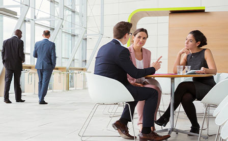 Business people discussing plans in a lobby.