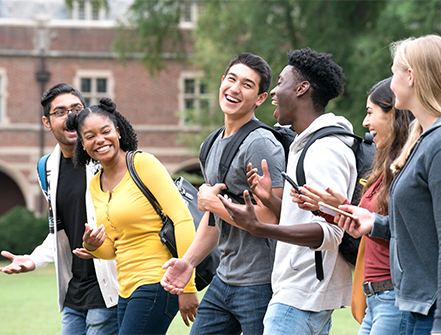 A group of students chatting happily while walking in the campus.