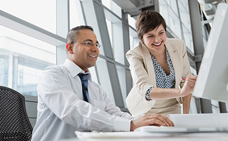 Businesswoman showing project on computer monitor in office building