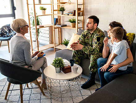 Un consultor empresarial se reúne con un veterano y su familia para hablar sobre oportunidades comerciales y programas especiales disponibles para propietarios de pequeñas empresas.