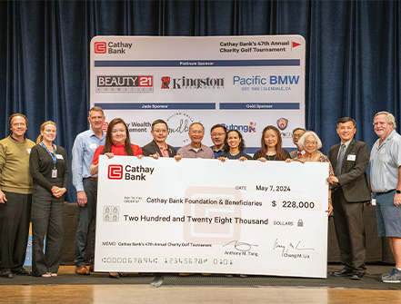 Cathay Bank entrega un cheque de $228,000 a representantes de organizaciones locales sin fines de lucro que se beneficiarán de los fondos recaudados en el torneo de golf del banco.