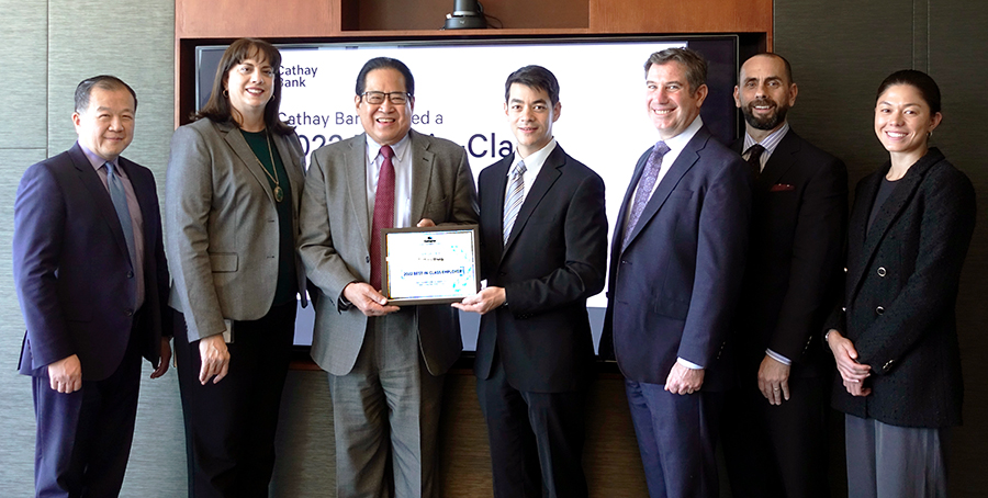 Team Members from Cathay Bank pose with the Gallagher Award and members from the firm in a conference room.