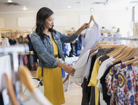 Woman eyeing shirt in clothing shop