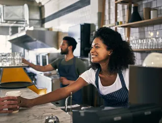 Young woman serving a customer in her coffee shop