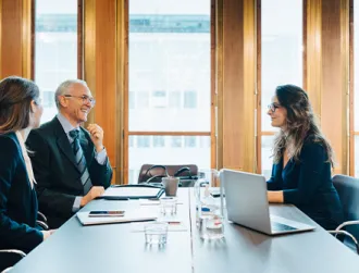 Lawyers in a professional setting discussing the management of client trust funds.