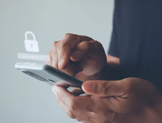Hands holding a smartphone with a padlock icon overlay, symbolizing mobile security and data protection against Godfather Malware.