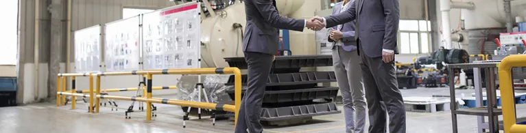 Business people shaking hands in the factory
