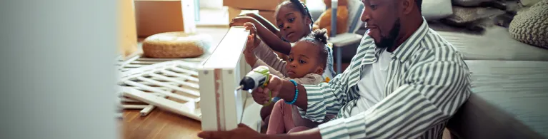 Daughters helping their dad make a crib