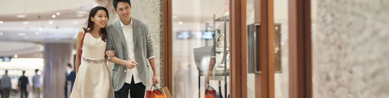 Happy couple window shopping in luxury mall