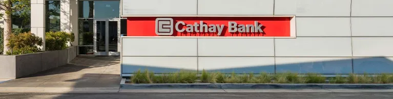 The grey Cathay Bank logo sits on a red background outside the headquarters in San Gabriel Valley, California. 