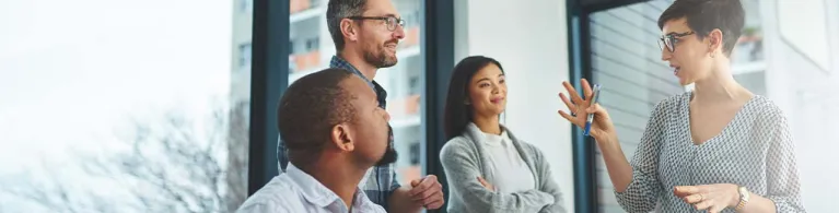 A group of people attends a meeting in a business conference room.