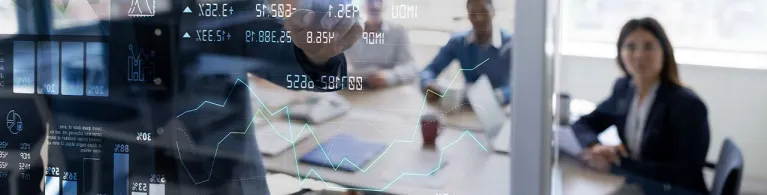 A group of business partners gather inside a meeting room to discuss stocks, investments, and more.