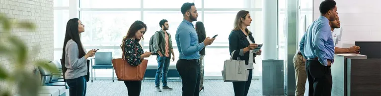 Bank customers form a line to see a bank teller and learn more about special rates. 