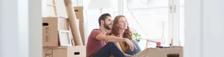 Young couple in new flat with cardboard boxes