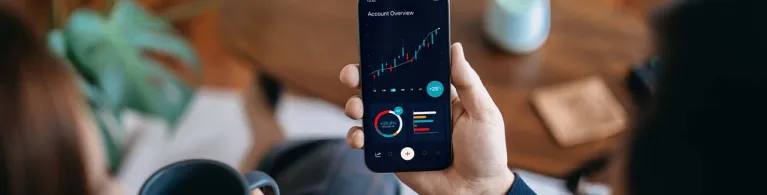 A couple sips coffee and tracks the foreign currency exchange value over a mobile application before they travel abroad.