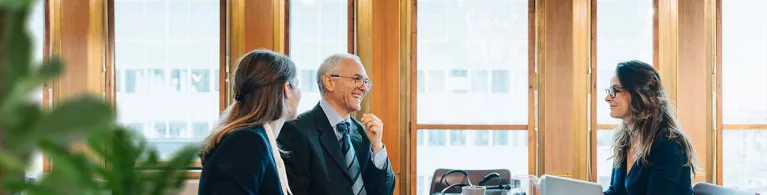 Lawyers in a professional setting discussing the management of client trust funds.