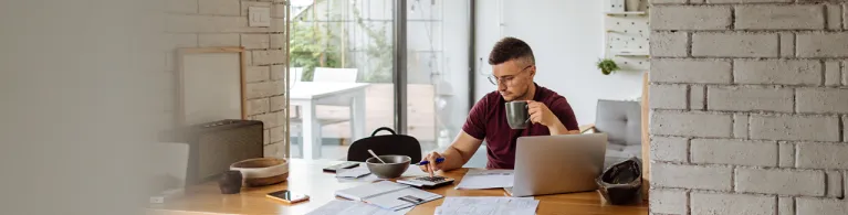Young man at home, paying bills online