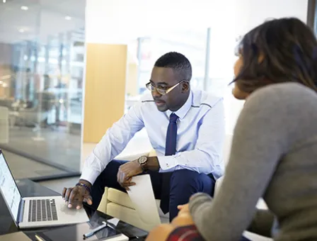 Business people working at laptop in office lobby