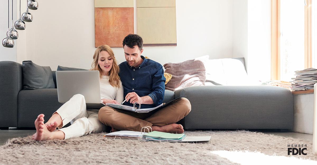 Couple with laptop looking at paperwork.