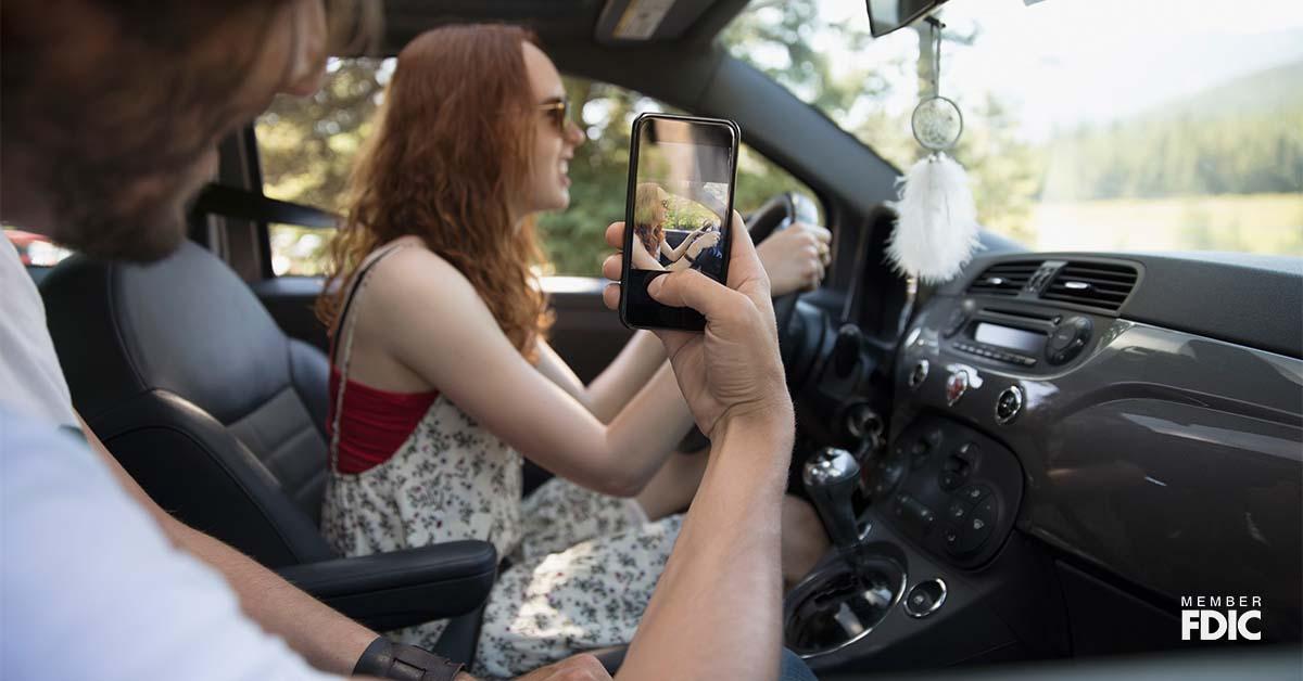 Boyfriend videotaping girlfriend driving car, enjoying road trip