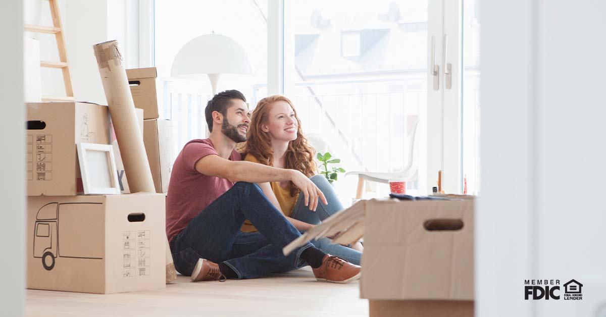 Young couple in new flat with cardboard boxes