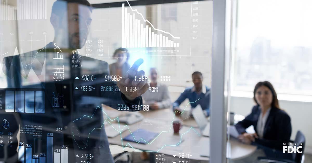 A group of business partners gather inside a meeting room to discuss stocks, investments, and more.