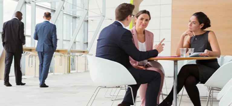 Business people discussing plans in a lobby.