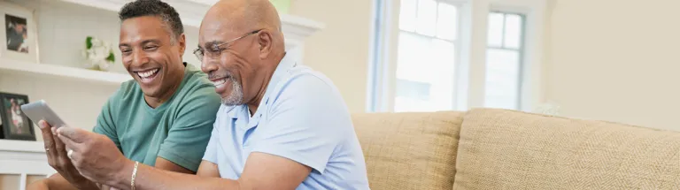 Mature man and father using digital tablet on sofa