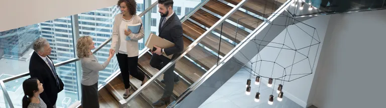 Business people handshaking on modern, urban office staircase