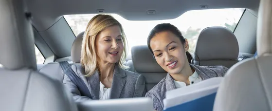 Business colleagues reviewing paperwork in car