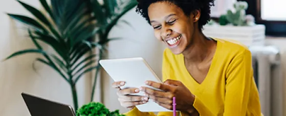 Young woman sitting at table with several portable device.