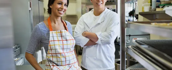 Smiling bakers standing in bakery