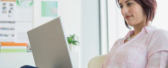 Businesswoman working at laptop in office.