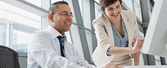Businesswoman showing project on computer monitor in office building