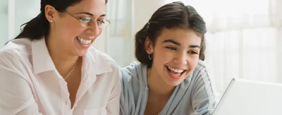 Mom and teen daughter using laptop