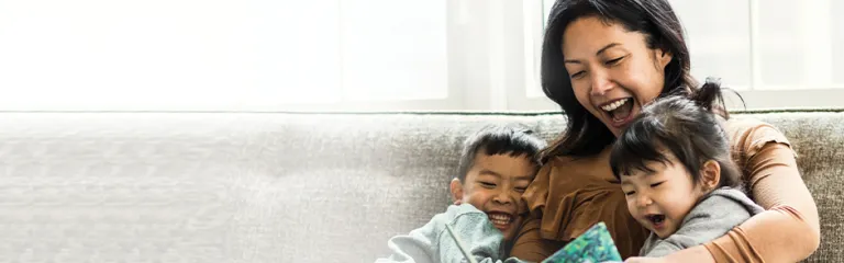 Mother reading to her son and daughter on couch