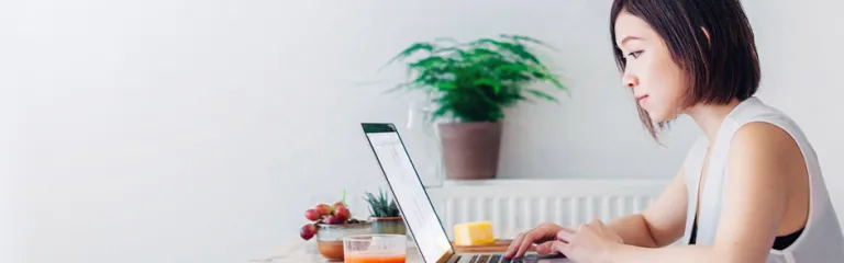 Young woman working whilst having breakfast
