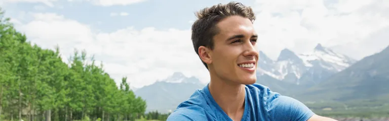 Man with mountain bike sitting in grass.