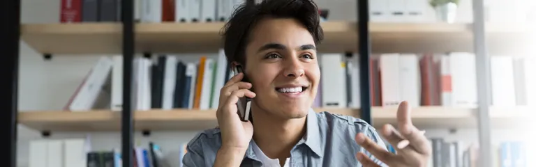 Young businessman talking on cell phone in office