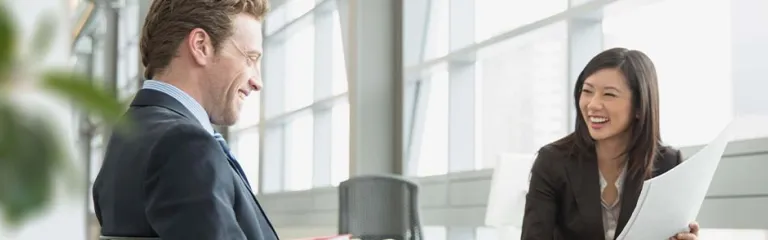 Business colleagues with paperwork laughing in office