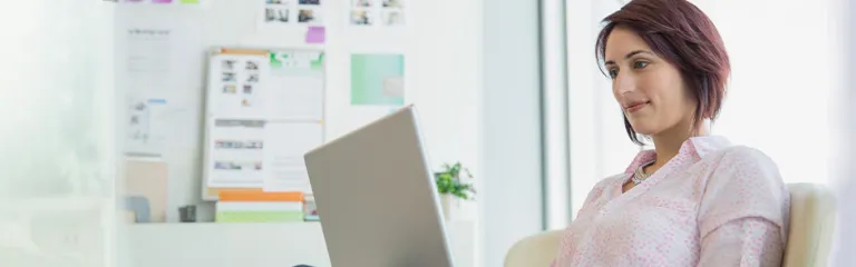 Businesswoman working at laptop in office.