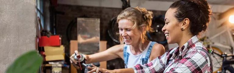 Two women fixing bicycle's in their workshop