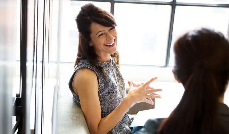Smiling businesswomen talking in office.